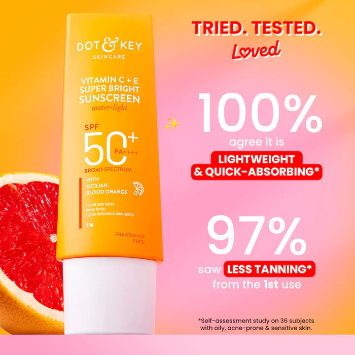 Dot & Key Vitamin C+E sunscreen tube on a pink background beside a grapefruit slice.
