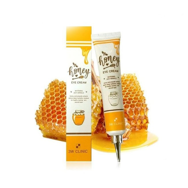 Honey eye cream packaging and tube in front of honeycomb and honey.