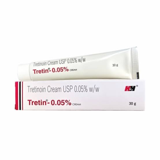 Tretinoin cream .05% tube resting on its white and red packaging box.