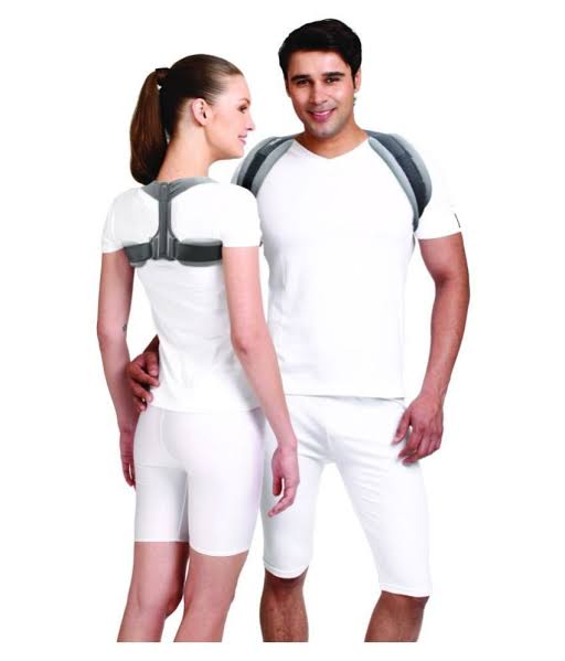 Man and woman in white outfits wearing posture corrector braces.