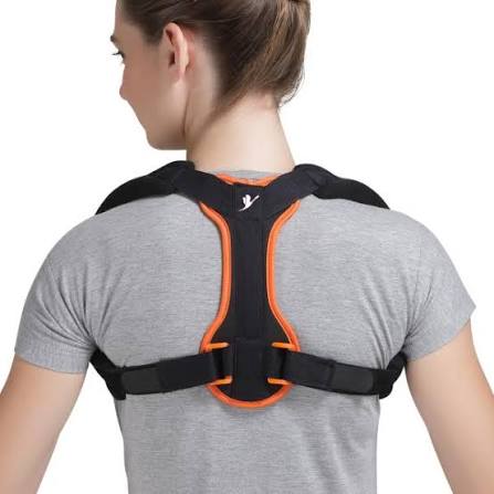 Woman wearing a black and orange posture corrector over a gray shirt.