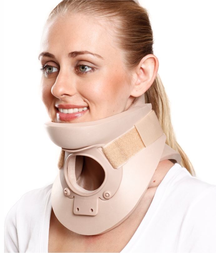 Woman wearing a beige medical neck brace and smiling.