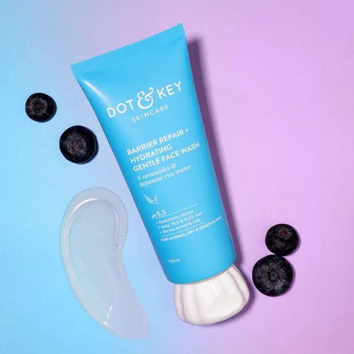 Blue skincare face mask tube with three blueberries and clear gel on a purple gradient background.