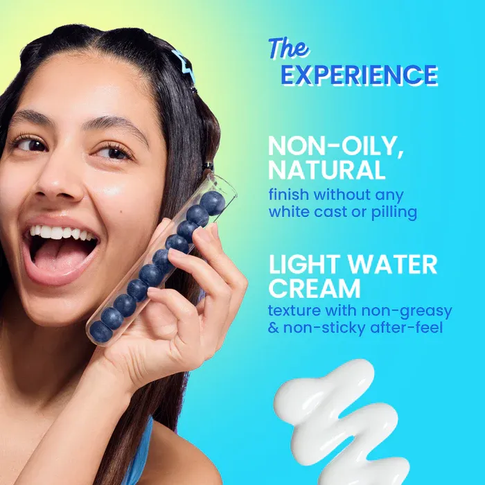 Smiling woman with long hair holding an ice roller, creamy white product on a blue background.