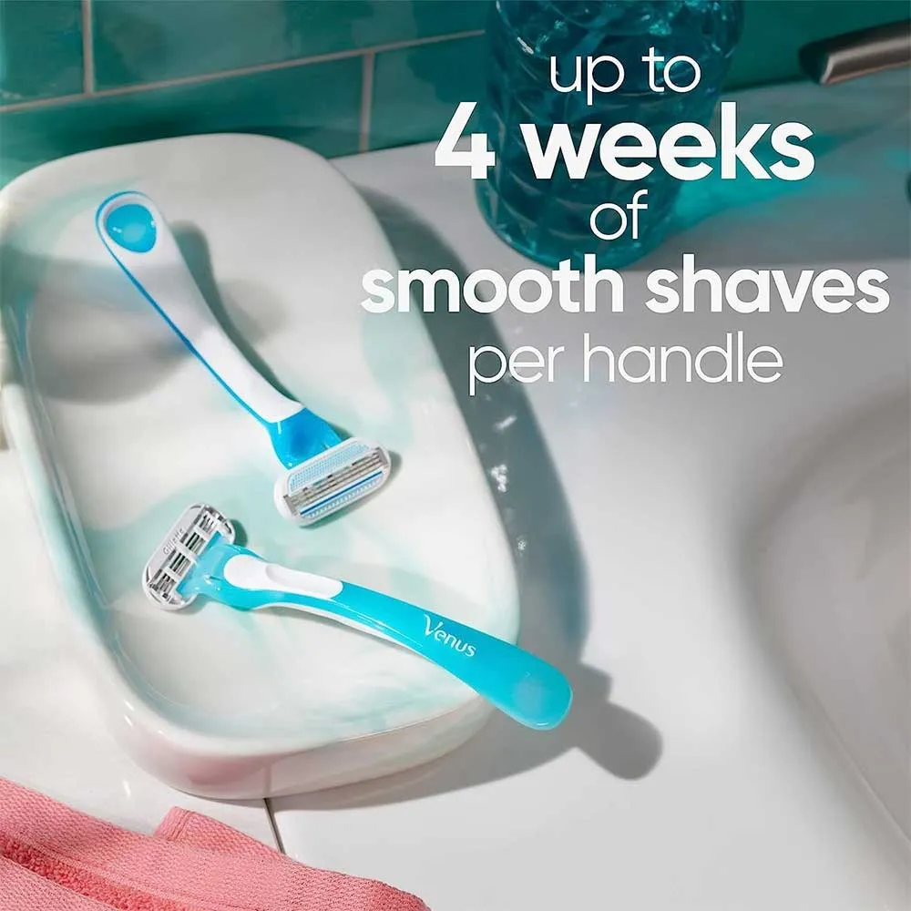 Two blue razors on a white soap dish by a bathroom sink.