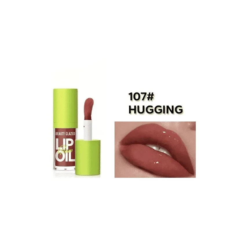 Lip oil product with green cap next to lips wearing matte brownish-red lip color.