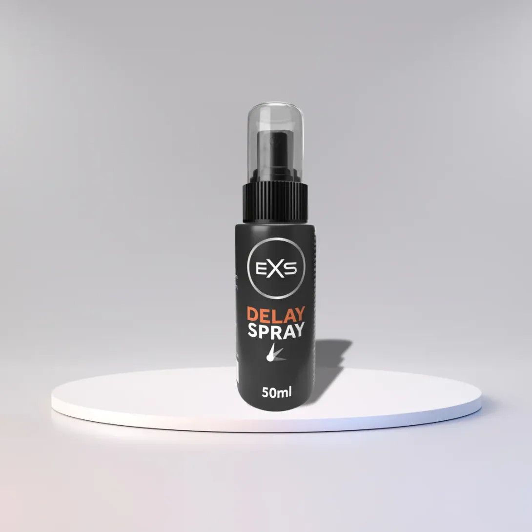 Black bottle of EXS Delay Spray with a clear cap on a white platform.