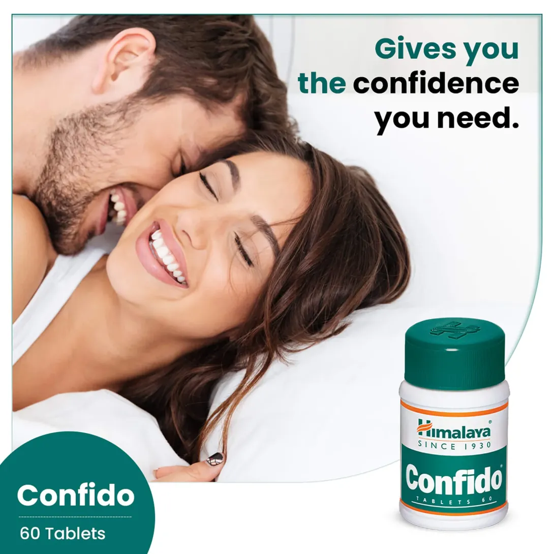 Smiling couple lying in bed next to a bottle of Himalaya Confido tablets.