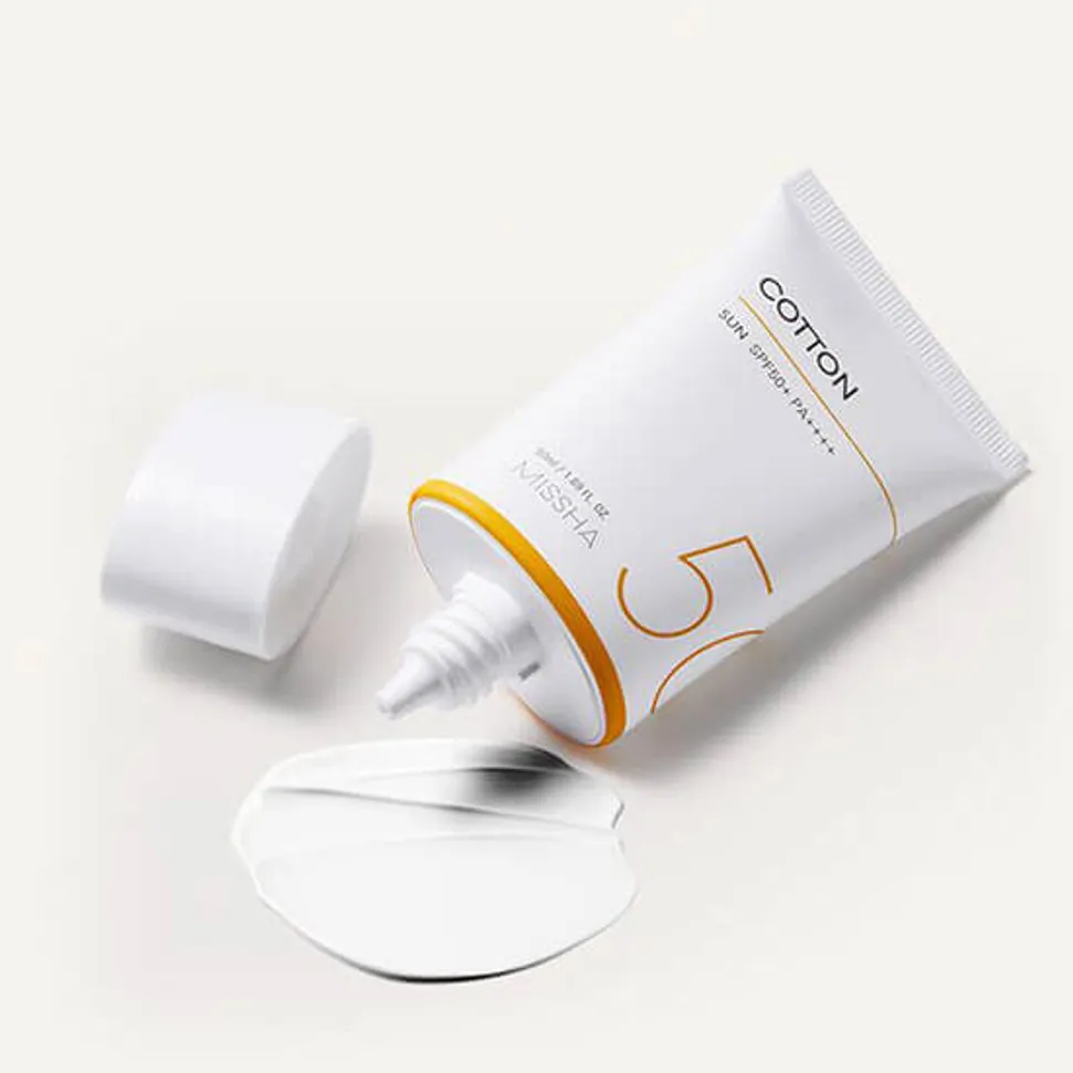White tube of skincare cream with a yellow accent, open cap, and foil seal.