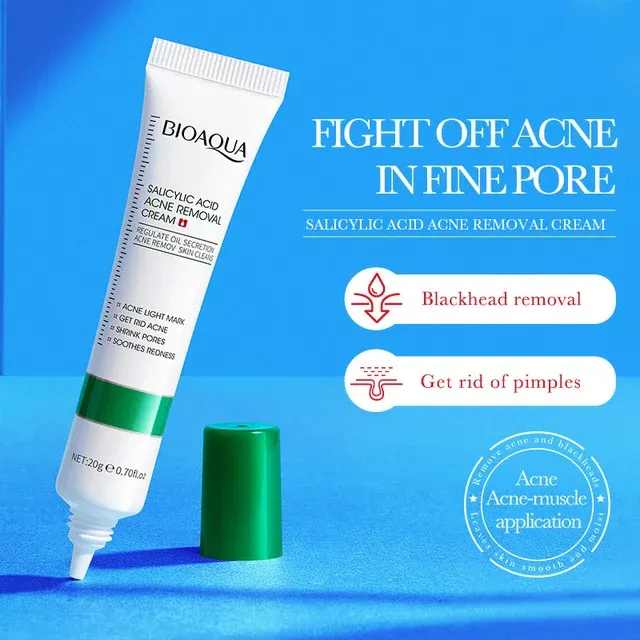 White and green tube of acne removal cream on a blue background with a green cap beside it.