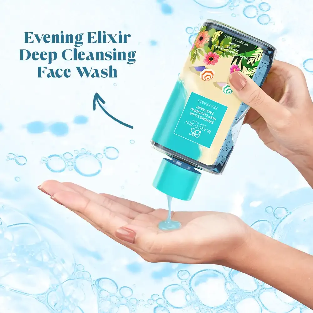 Hand pouring liquid face wash from a floral bottle onto palm, blue bubbles in background.