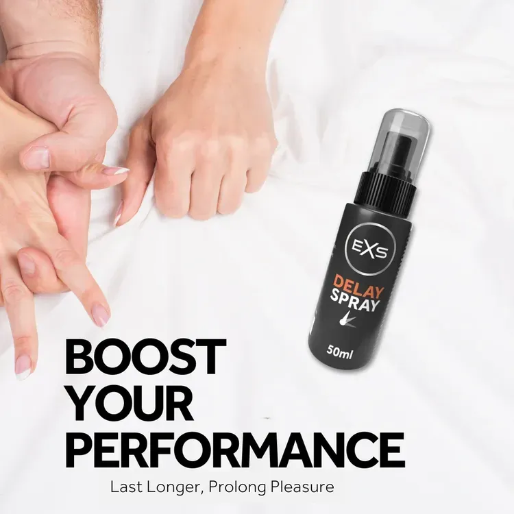 Black delay spray bottle on white bed near intertwined hands.