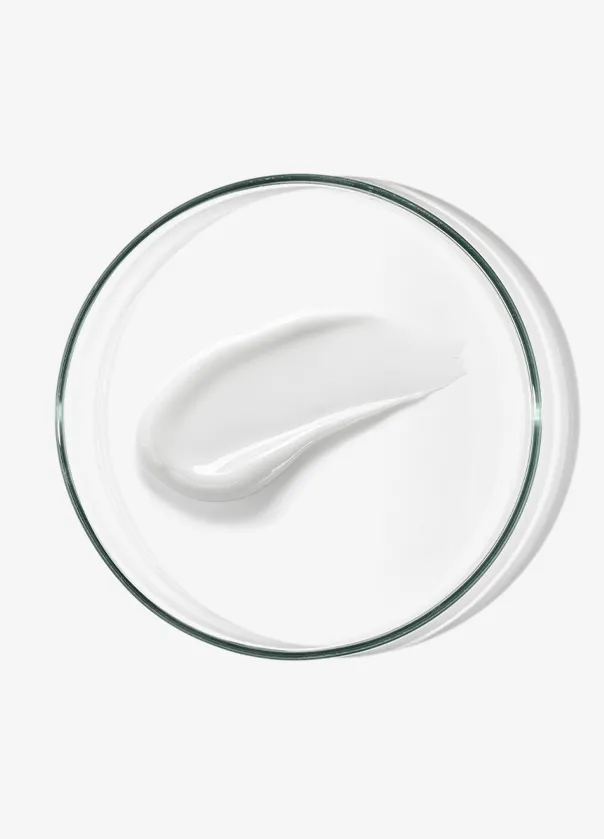White cream smear on a clear glass dish against a light background.