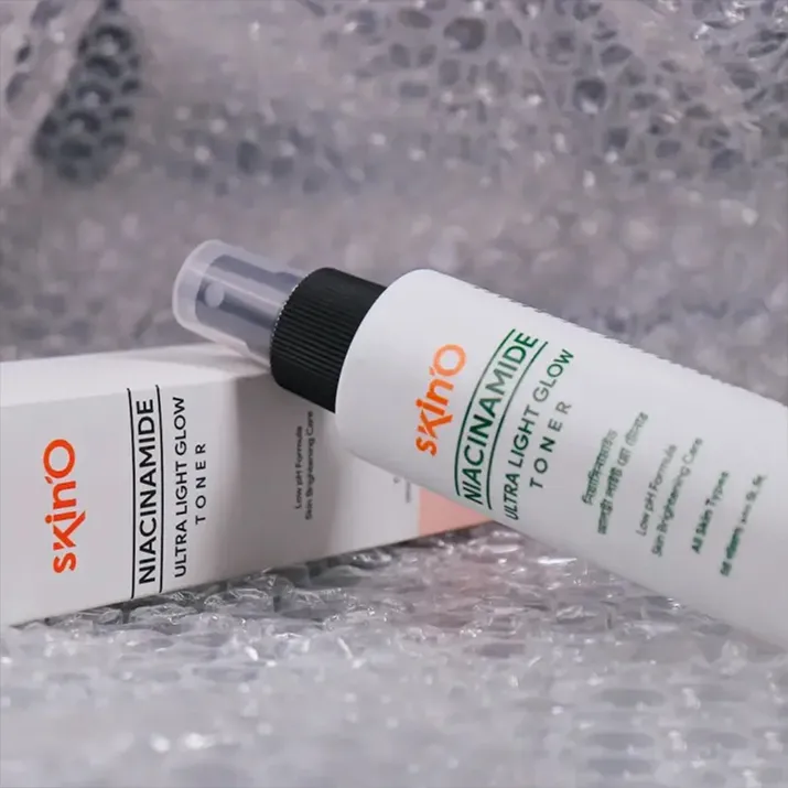 White bottle of Skino toner with matching box on bubble wrap background.