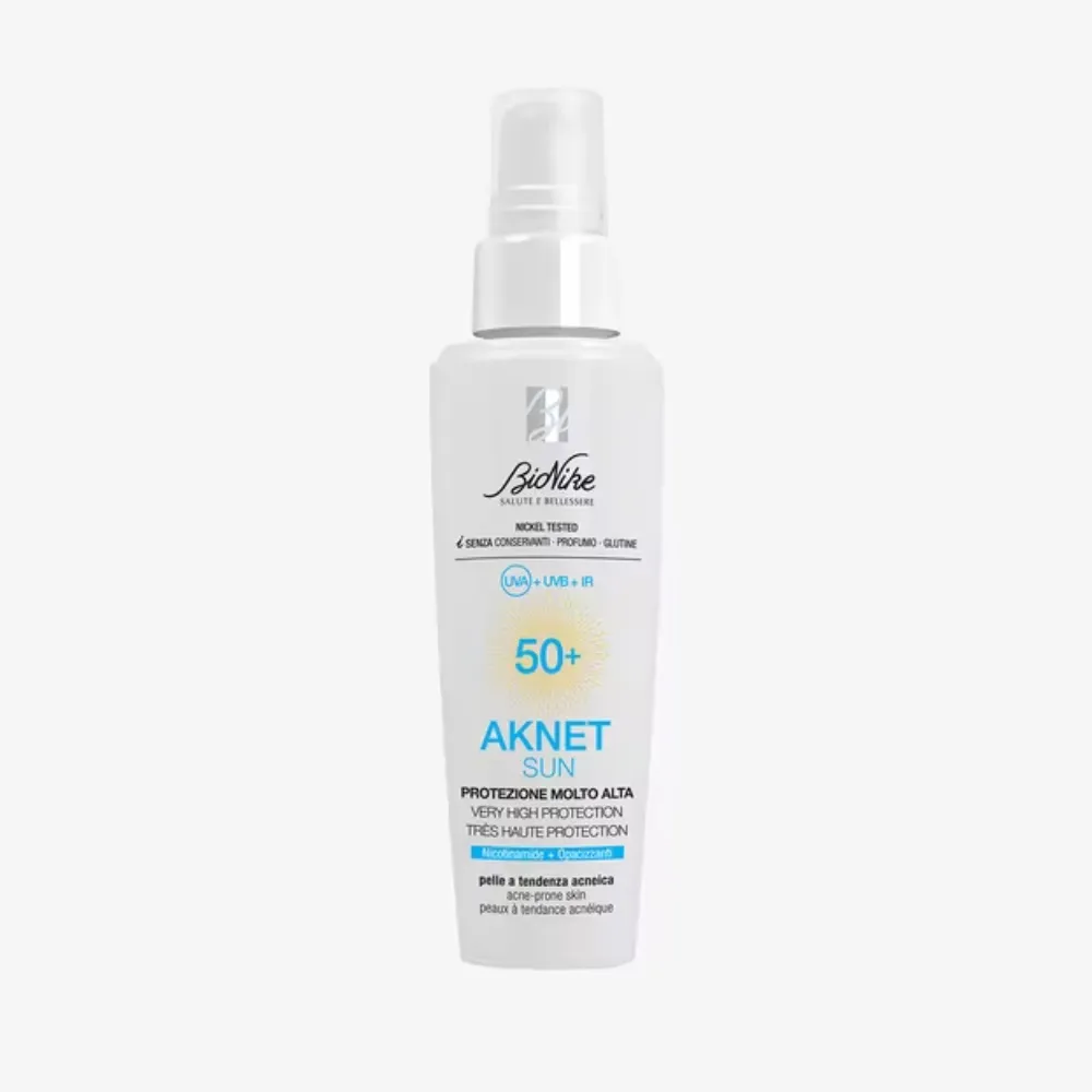 White sunscreen spray bottle labeled SPF 50+ with blue and yellow accents on a light background.