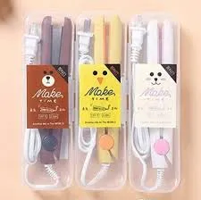 Three colorful mini hair straighteners in plastic cases with cute animal-themed labels.