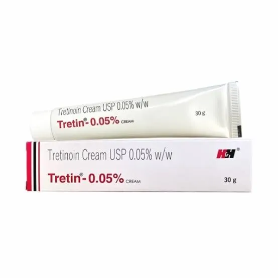 Tretinoin cream .05% tube resting on its white and red packaging box.