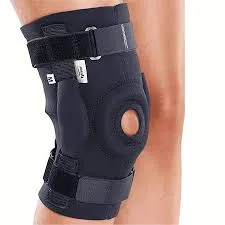 Black knee brace with straps and open patella worn on a person's leg.